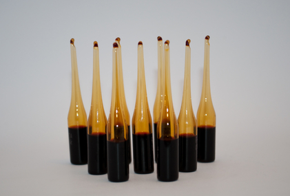 A group of black and brown syringes on a white surface, representing functional health.
