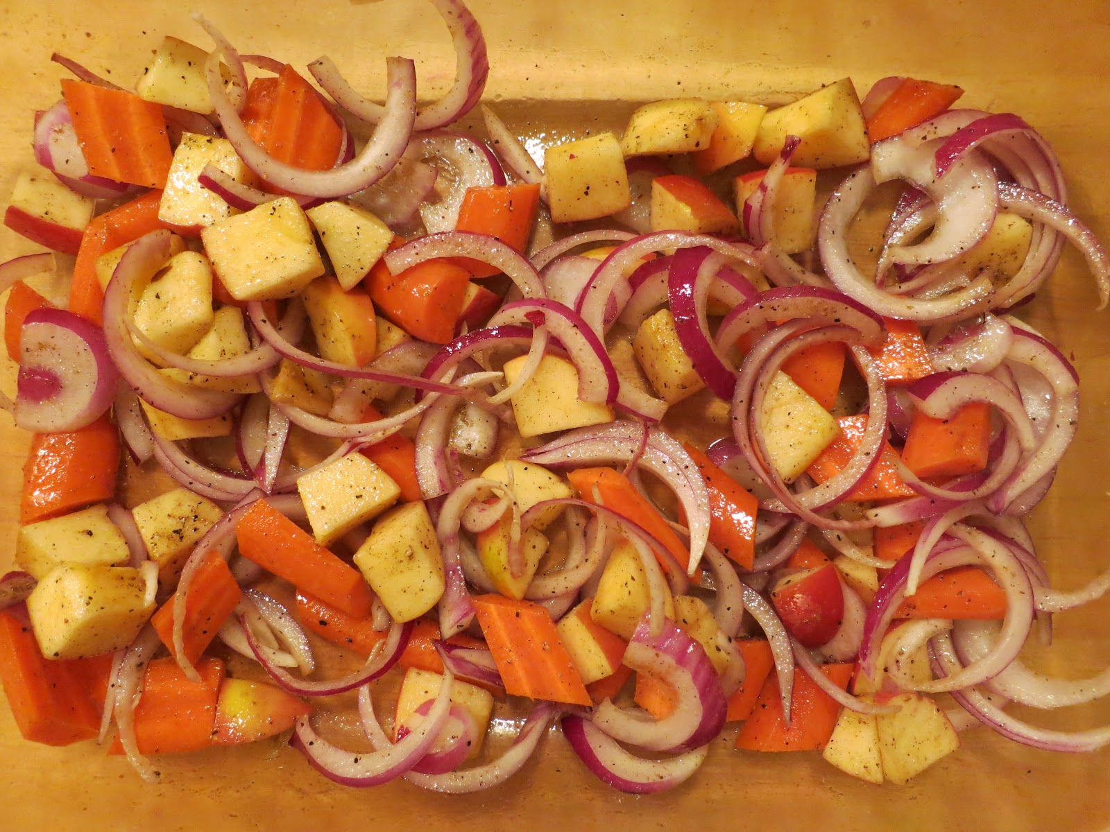 A tray of sliced carrots, onions, and potatoes.