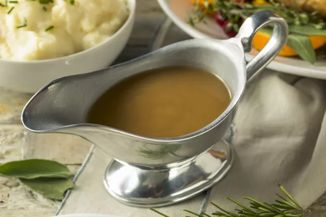 Gravy and mashed potatoes on a table with sprigs of rosemary promote functional health.