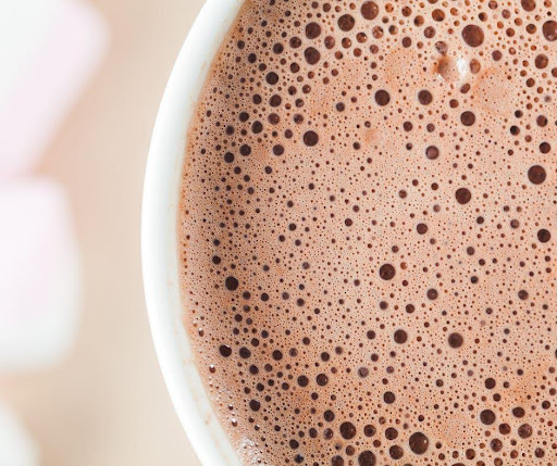 A close up of a cup of hot chocolate with marshmallows.