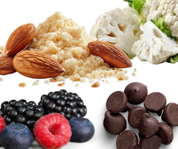 An assortment of almonds, almond flour, cauliflower florets, blackberries, raspberries, blueberries, and dark chocolate chips arranged on a white background.